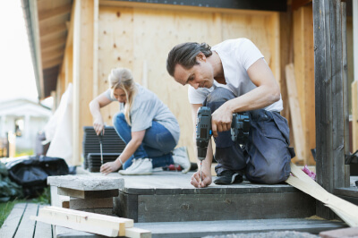 Couple outside renovating and remodeling their deck space.